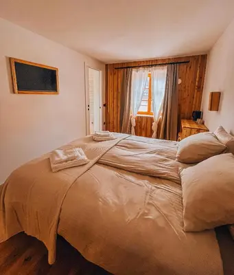 a large bed in a bedroom with a window at Maison Lenka in Rateče