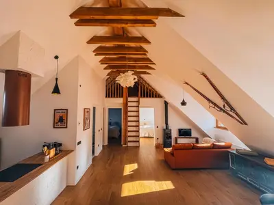 a living room with wooden beams and a staircase at Maison Lenka in Rateče