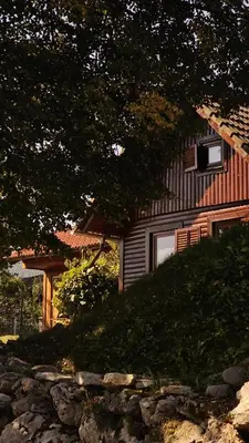 a house with a stone fence in front of it at Lake house Amur in Kočevje