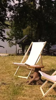 two lawn chairs sitting on top of a tree stump at Lake house Amur in Kočevje