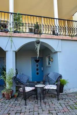 a patio with chairs and a table under a balcony at Vila Kralj in Podčetrtek