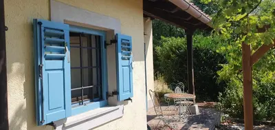 an open window with blue shutters on a house at Karsolina in Štanjel