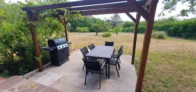 a patio with a table and chairs and a grill at Karsolina in Štanjel