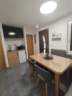 a kitchen and dining room with a wooden table and chairs at Hiška 4005 - Terme Čatež in Brežice