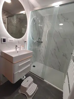 a bathroom with a sink and a shower with a mirror at Hiška 4005 - Terme Čatež in Brežice