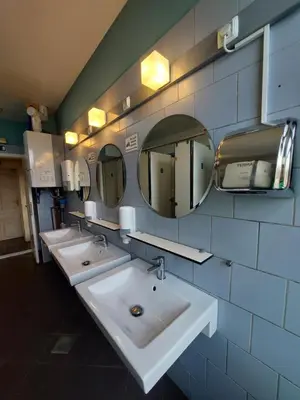 a bathroom with three sinks and two mirrors at Bella Veselova in Ljubljana