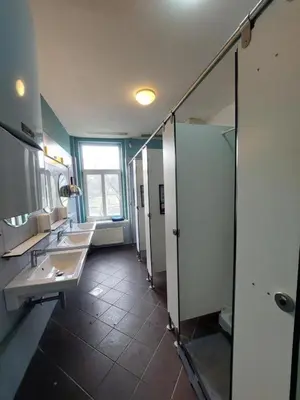 a bathroom with three sinks and a mirror at Bella Veselova in Ljubljana