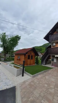 a small wooden building in front of a building at Apartment Tijana in Nomenj
