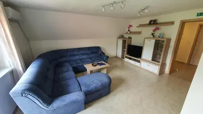a living room with a blue couch and a tv at Apartment Tijana in Nomenj
