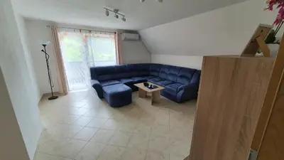 a living room with a blue couch and a table at Apartment Tijana in Nomenj