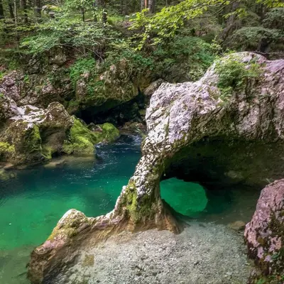 a rock formation in a river with blue water at Apartment Tijana in Nomenj