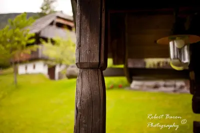 a close up of a wooden table with a house in the background at Domačija Koklej - Apartments Vintage Vacation in Luče