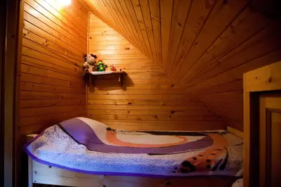a bedroom with a bed in a wooden room at Domačija Koklej - Apartments Vintage Vacation in Luče