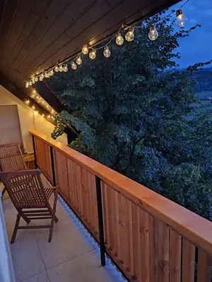 a porch with a bench and a chandelier at Hiška na skalci, The House on the Rock in Krka