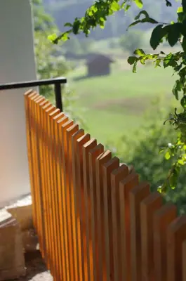 an orange fence with a view of a field at Hiška na skalci, The House on the Rock in Krka