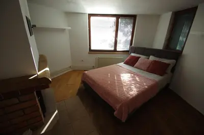 a bedroom with a bed with red pillows and a window at Hiška na skalci, The House on the Rock in Krka