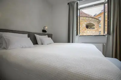 a bedroom with a large white bed and a window at Hiša Barbara in Celje