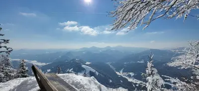 a bench on top of a mountain in the snow at Apartments Na Žagi in Železniki