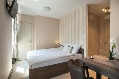 a bedroom with a bed and a table and a desk at Hotel Pri mostu in Dolenjske Toplice