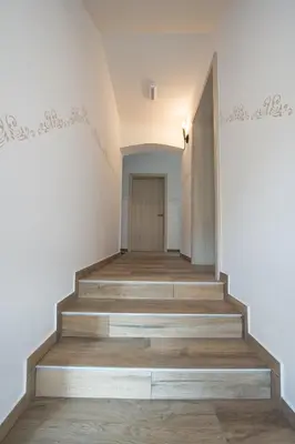 a staircase in a house with wooden floors and white walls at Hotel Pri mostu in Dolenjske Toplice