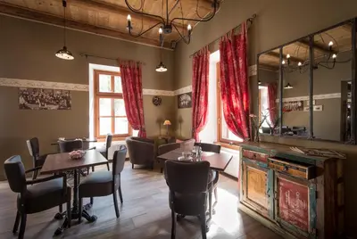 a dining room with tables and chairs and a mirror at Hotel Pri mostu in Dolenjske Toplice