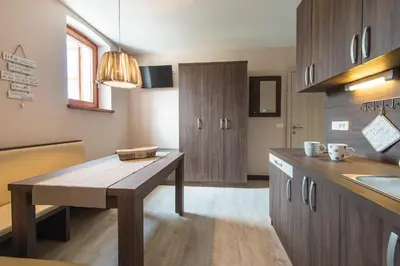a kitchen with wooden cabinets and a wooden table at Hotel Pri mostu in Dolenjske Toplice