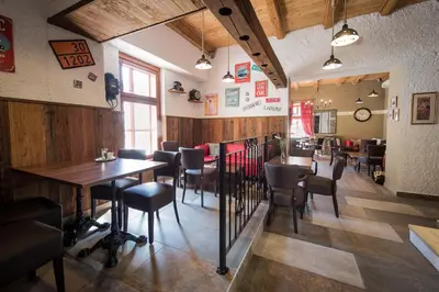 a restaurant with wooden walls and tables and chairs at Hotel Pri mostu in Dolenjske Toplice