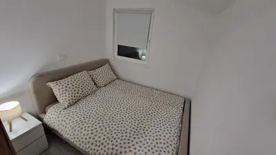 a small bedroom with a bed with a mirror at Hiška Betnava - G115 in Podčetrtek