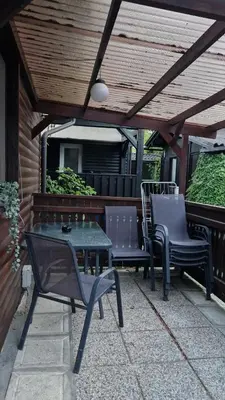 a patio with a table and chairs under a wooden roof at Hiška Betnava - G115 in Podčetrtek