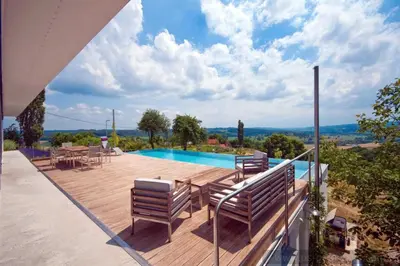 a patio with chairs and a swimming pool on a house at Exklusive Premium-Lodge mit Pool, Sauna, Gästehaus