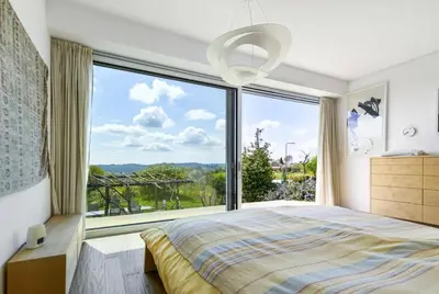 a bedroom with a large window and a bed at Exklusive Premium-Lodge mit Pool, Sauna, Gästehaus