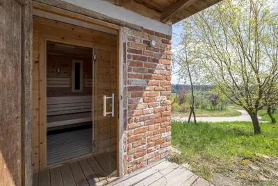 a brick building with a door on a porch at Exklusive Premium-Lodge mit Pool, Sauna, Gästehaus