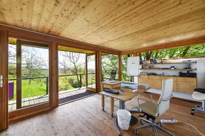 an office with a desk and chairs in a room with windows at Exklusive Premium-Lodge mit Pool, Sauna, Gästehaus