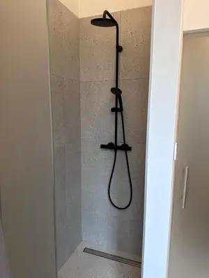 a shower with a black shower head in a bathroom at Spacious Designer Apartment in heart of the town in Maribor