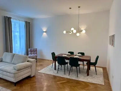 a living room with a dining room table and a couch at Spacious Designer Apartment in heart of the town in Maribor