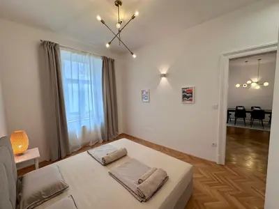 a bedroom with a white bed with two pillows on it at Spacious Designer Apartment in heart of the town in Maribor