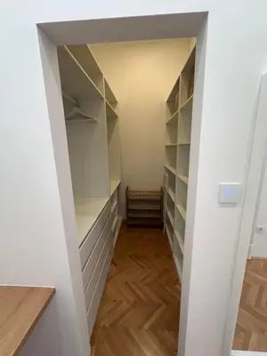 a walk in closet with white walls and wooden floors at Spacious Designer Apartment in heart of the town in Maribor