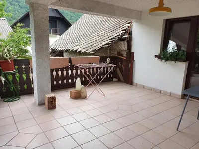 a patio with a table in a house at Apartmaji Julijana Podlipnik in Bohinj
