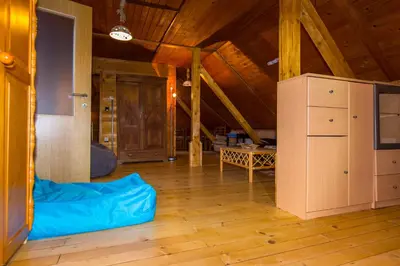 a large room with wooden floors and a wooden ceiling at Brunarica Bled Zatrnik Pokljuka in Bled