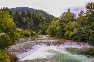 a waterfall in the middle of a river at Brunarica Bled Zatrnik Pokljuka in Bled