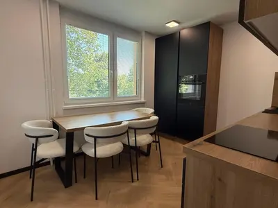 a kitchen with a table and chairs and a window at Moderno stanovanje - Ptuj in Ptuj