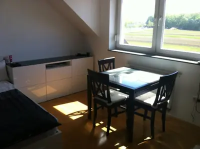 a dining room with a table and chairs and a window at Andro's modern studio apartment in Ljubljana