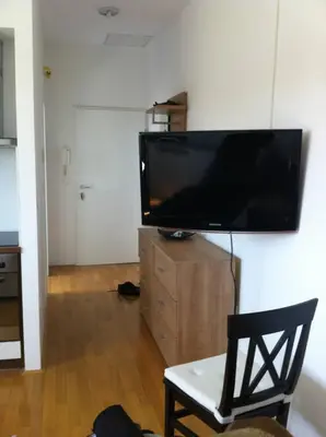 a living room with a large flat screen tv on a wall at Andro's modern studio apartment in Ljubljana