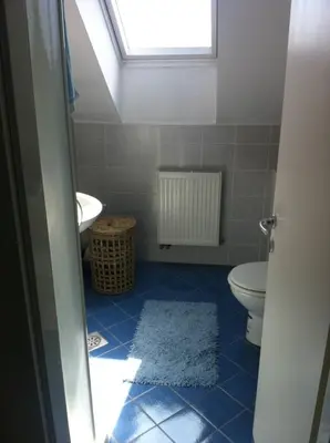 a bathroom with a toilet and a sink and a window at Andro's modern studio apartment in Ljubljana