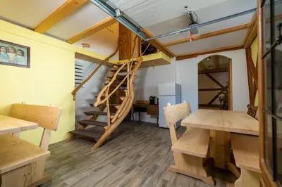 a room with a spiral staircase and wooden floors at Sobe na skednju in Bohinjska Bistrica