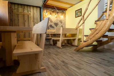 a room with a bench and a table and stairs at Sobe na skednju in Bohinjska Bistrica