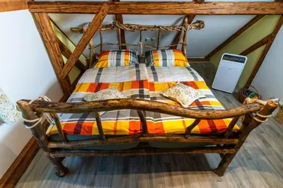 a wooden bed with pillows on it in a room at Sobe na skednju in Bohinjska Bistrica
