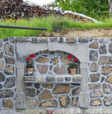 a stone fireplace with two potted plants on it at Domačija Blaževc in Žiri