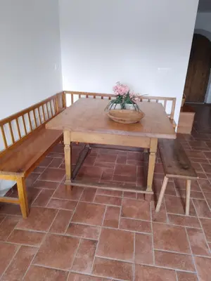 a wooden table and bench in a room at Domačija Blaževc in Žiri