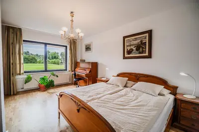 a bedroom with a large bed and a piano at Parkside Haven with 4 Bedrooms & free parking in Ljubljana